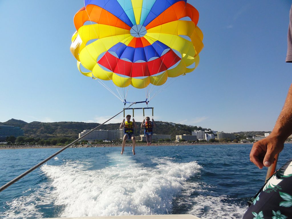 Two people parachuting over the water.