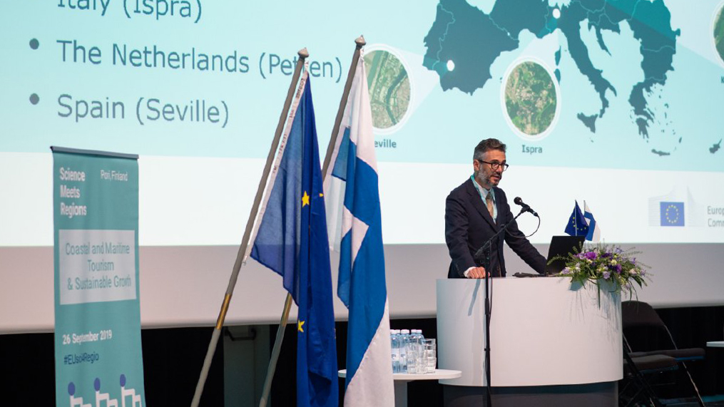A person giving a speech at the Science Meets Regions event at SAMK. The map of Europe on the background.