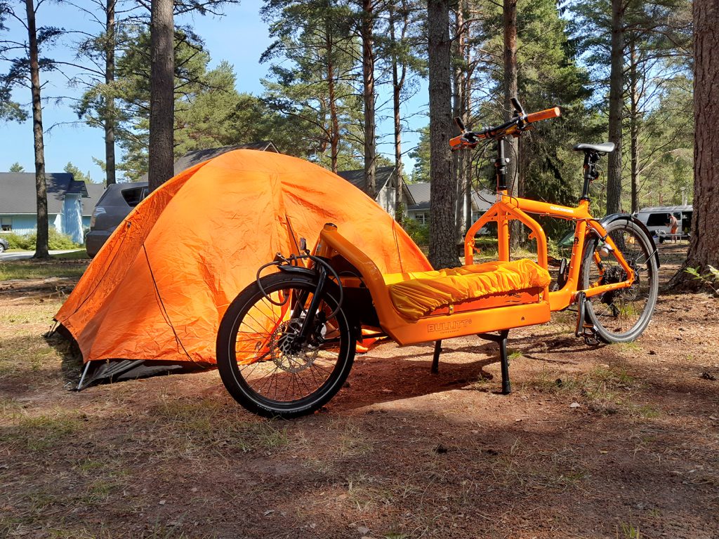Kesäisessä metsässä pyörä ja teltta.