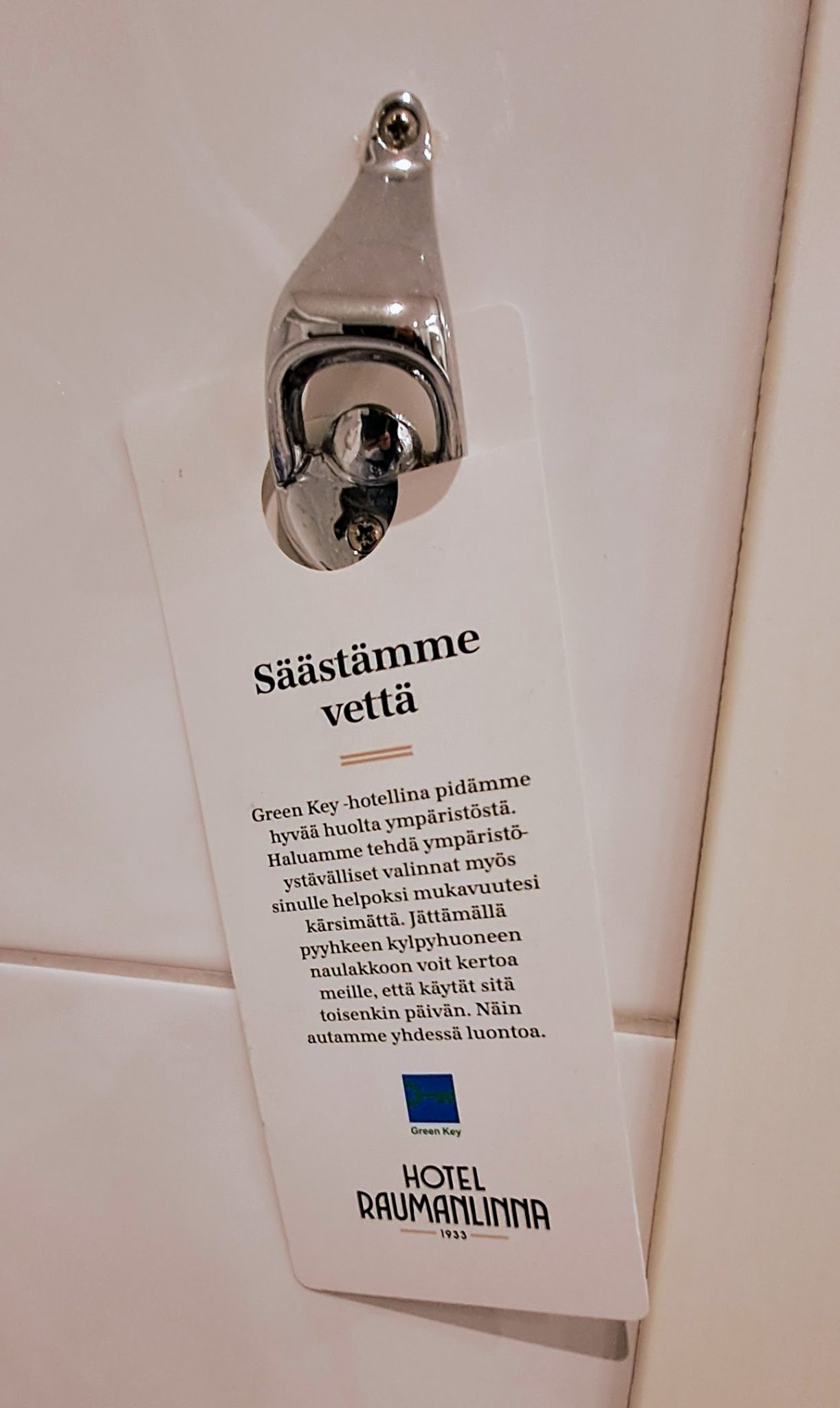 Säästämme vettä kyltti ovessa.
