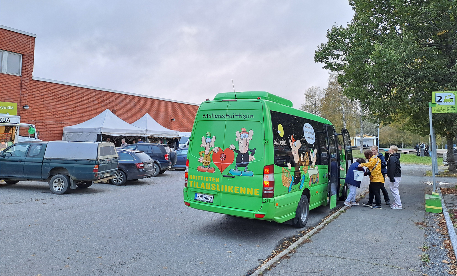 Kaupunkibussi bussipysäkillä. Bussin takana lukee #Hullunahuittisiin.