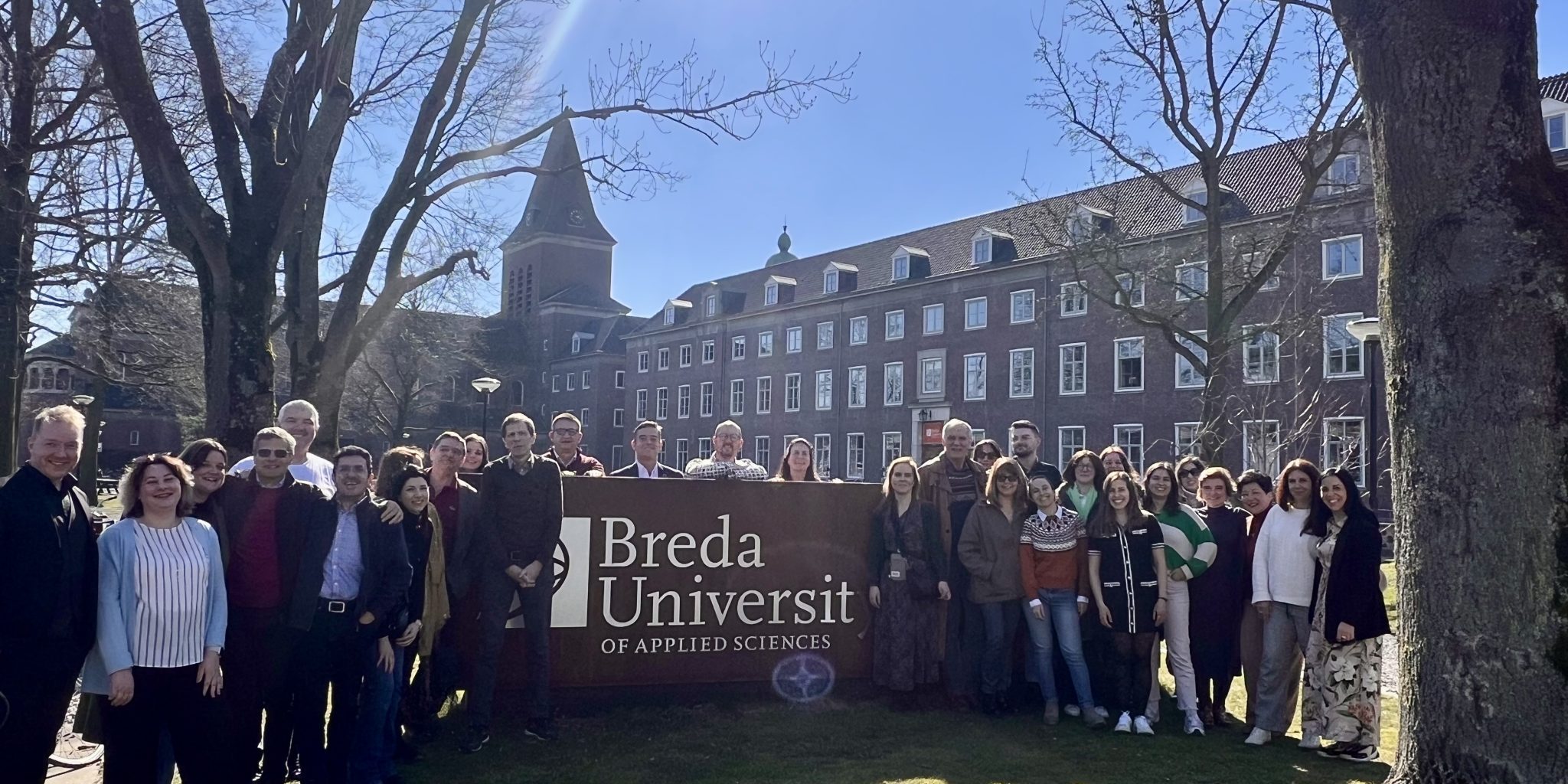 People in a group photo in a spring landscape.