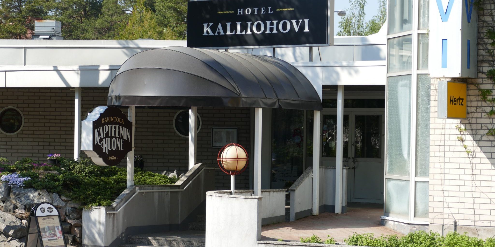 Ulkokuva Kalliohovin edestä. Ulko-ovi ja markiisi.