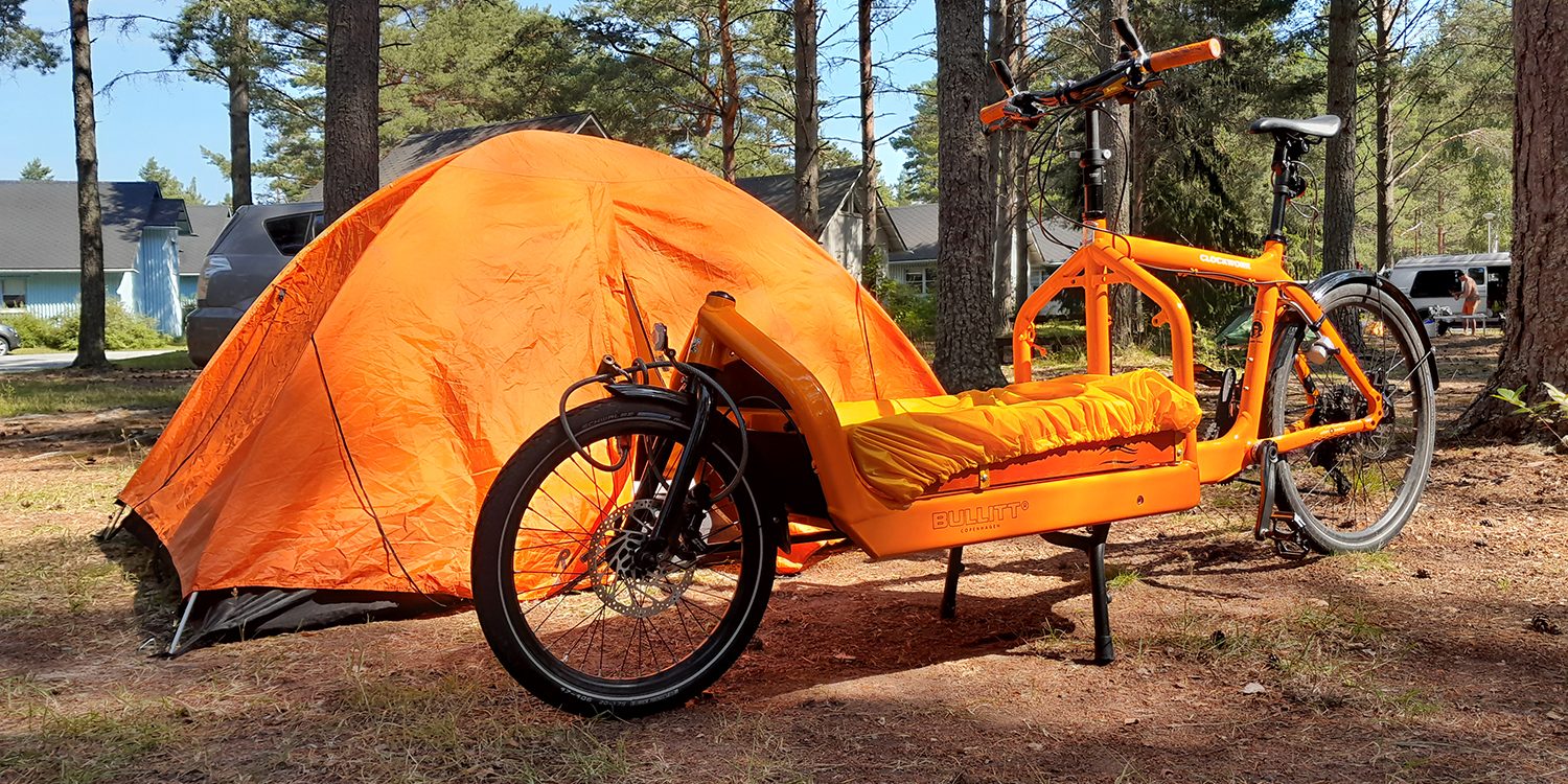 Kesäisessä metsässä pyörä ja teltta.