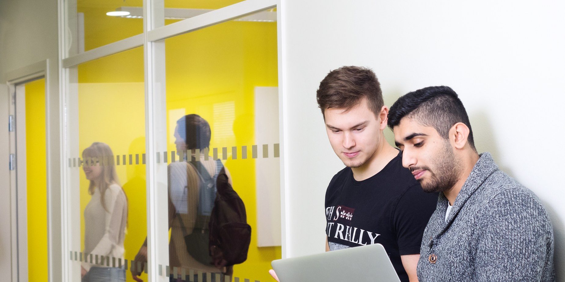 Two men looking at a laptop.