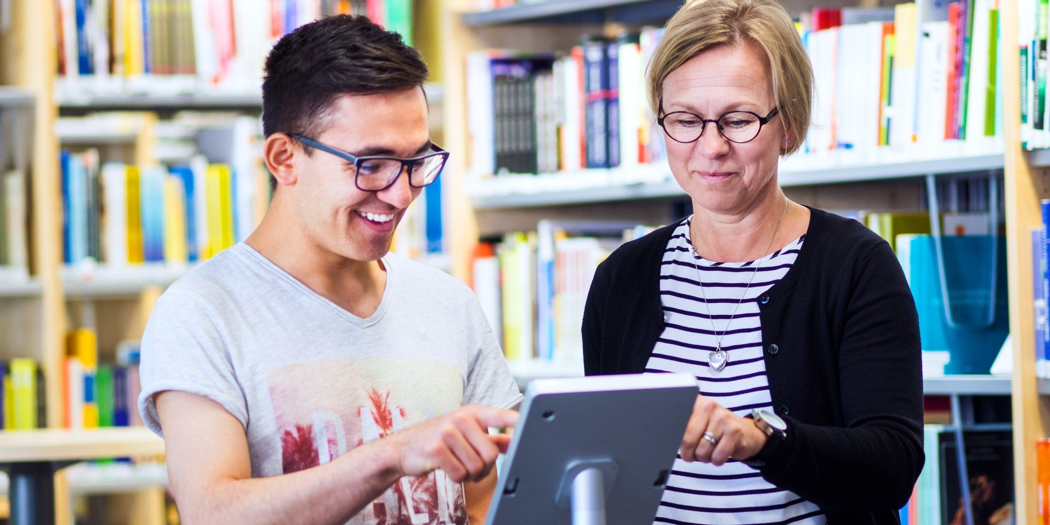 Woman and man looking on a tablet.