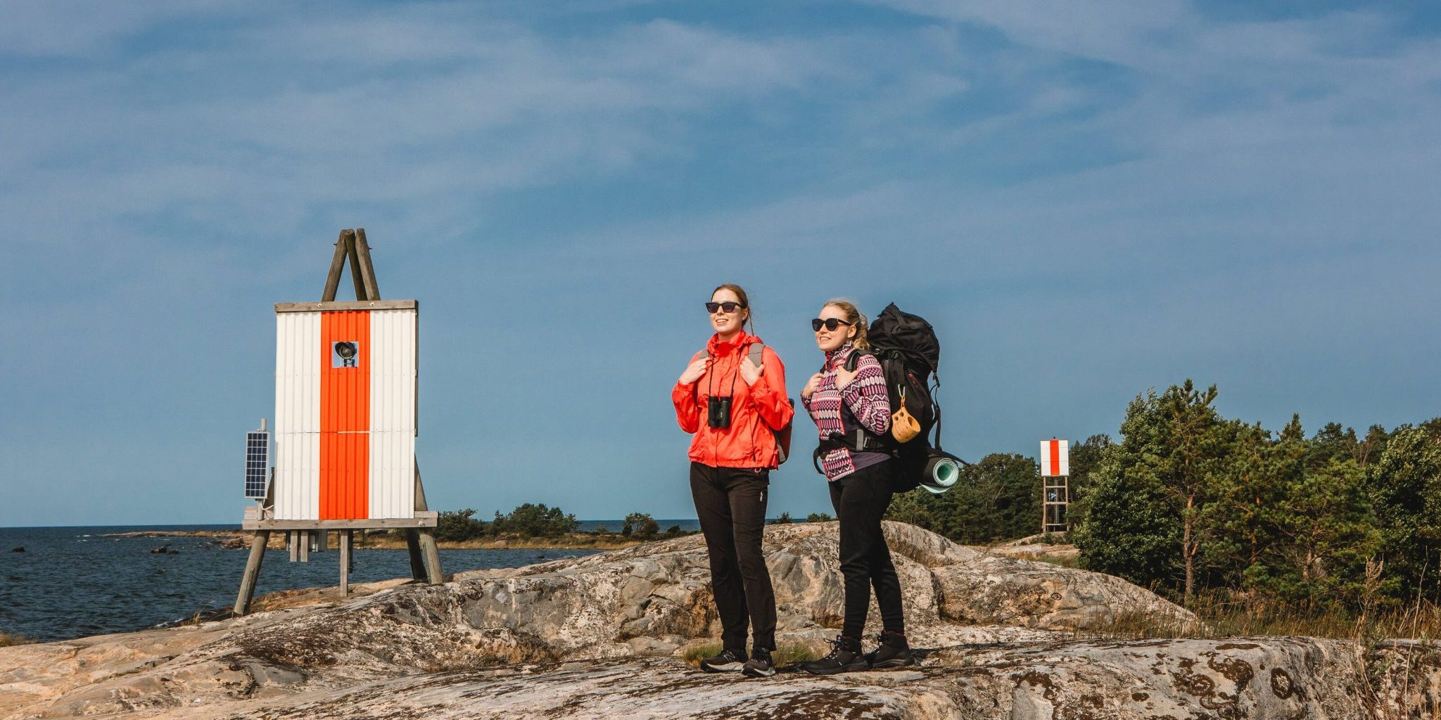 VF Rauma7 Kuva Rauman Kaupunki Kaksi naista rinkat selässä kallion päällä meren rannalla.